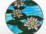 a picture of a stained glass sun catcher with white flowers