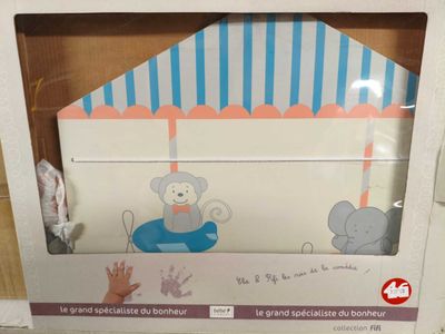 une boîte sur laquelle est représenté un bébé éléphant et dans laquelle se trouve un bébé éléphant