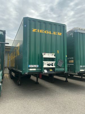 deux camions verts garés l'un à côté de l'autre sur un parking
