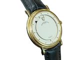 a gold watch with a white dial on a black leather strap