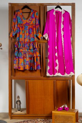 deux robes suspendues à un portant dans une pièce