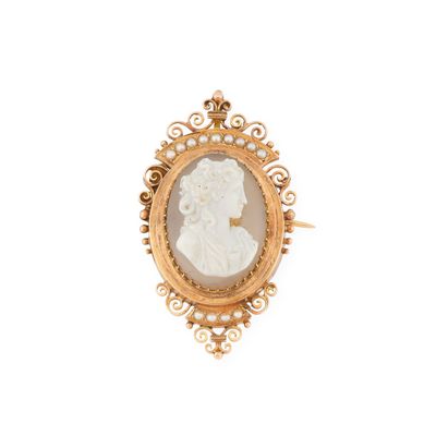 un gros plan sur une broche-camaïeu dorée et blanche