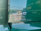 a mercedes benz logo on the side of a green truck