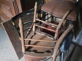une chaise en bois avec une assise marron, placée dans une pièce