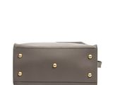 a grey leather handbag with gold studding on the front