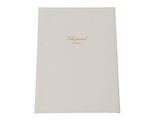 a white notebook with gold writing on the cover