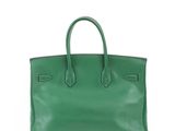a green leather tote bag on a white background