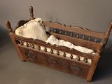 a small doll bed with a blanket on top of it
