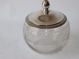 a glass jar with a silver lid sitting on a table