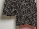 a close up of a black and white jacket and skirt on a hanger