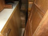 a wooden cabinet with a drawer in the middle of it