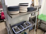 many plates and utensils on the shelf in the kitchen