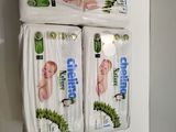 three packs of baby diapers hanging on a wall in a bathroom