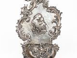 une assiette en argent sur laquelle est représentée une femme