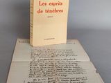 un vieux livre posé sur une feuille de papier, elle-même posée sur une table