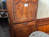 une grande armoire en bois surmontée d'une porte vitrée