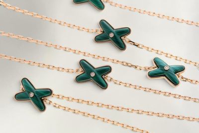 six croix en émail vert suspendues à des chaînes en or et ornées de diamants
