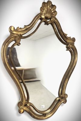 a gold mirror hanging on a wall in a room