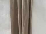 a beige skirt hanging on a hanger on a white wall