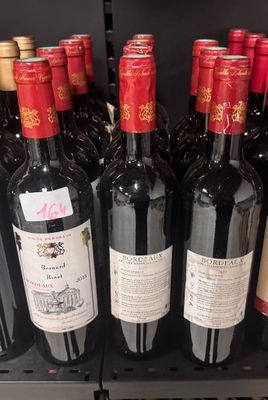 many bottles of wine sitting on a shelf in a store