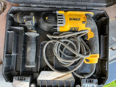 un outil dans une boîte à outils, muni d'un cordon et d'une perceuse