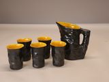 cinq tasses et un pichet posés sur une table