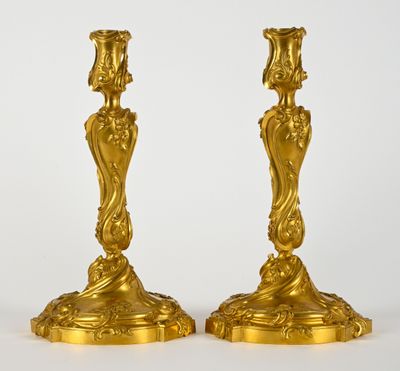 une paire de bougeoirs anciens dorés sur fond blanc