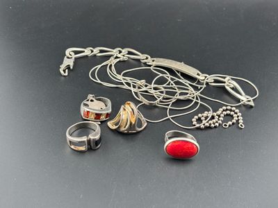 plusieurs bagues et colliers différents posés sur un fond noir