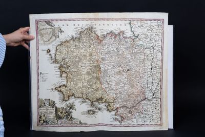 someone holding up a map of ireland in front of a black background