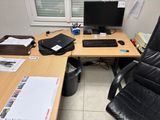 a desk with a computer and a chair in front of a window