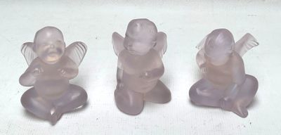 trois figurines en plastique représentant des anges assis sur une surface blanche