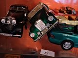 trois petites voitures exposées dans une vitrine