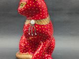 a red cat figurine sitting on top of a table