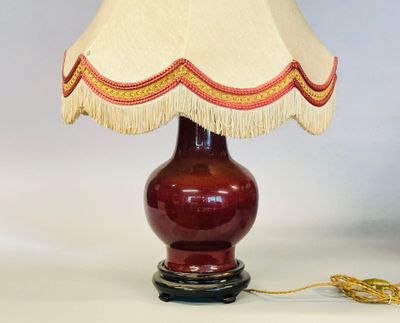 une image représentant une lampe avec un pied rouge et un abat-jour beige