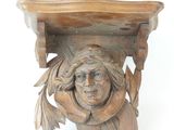 une étagère en bois sur laquelle est sculptée une tête