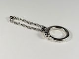 a silver ring on a chain on a white surface