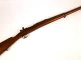 un fusil avec un canon en bois sur fond blanc