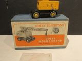 a yellow crane sitting on top of a box on a table