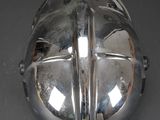 a silver helmet on a table with a black background