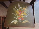 a painting on the back of a chair that has flowers painted on it