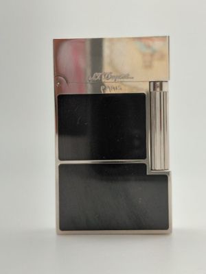 une photo d'un étui à cigarettes argenté posé sur une table blanche