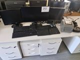 trois écrans d'ordinateur et un clavier posés sur un bureau