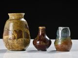 three vases are sitting on a table with a black background