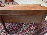 a small wooden table with a drawer on top of it