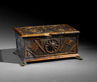 une vieille boîte en bois ornée de sculptures, posée sur une table