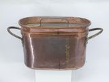 copper pot with handles and handles on a white pedestal