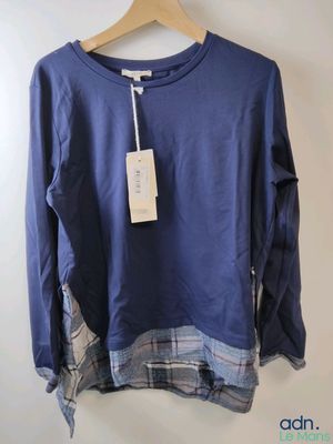 a close up of a shirt hanging on a hanger on a wall