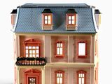 une maison de poupées avec un balcon, surmontée d'un autre balcon