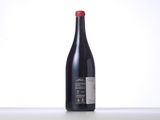 a bottle of red wine sitting on top of a table