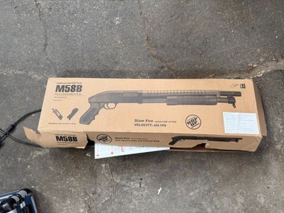 a box with a gun on the ground next to a remote control